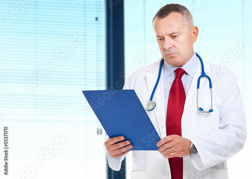 Photo: Doctor reading a case history Doctor reading a case history