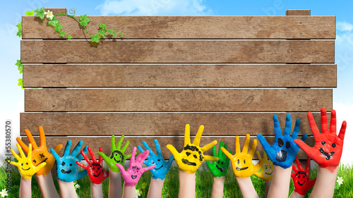Photo: lanchende Kinderhände vor Holzschild lanchende Kinderhände vor Holzschild