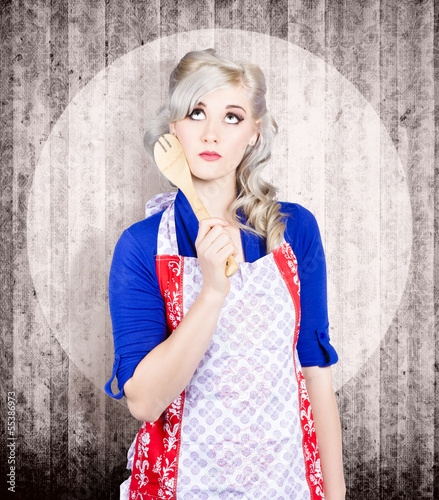 Photo: Young pinup housewife thinking what to cook Young pinup housewife thinking what to cook