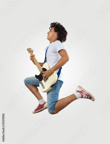 Photo: young man playing on electro guitar and jumping young man playing on electro guitar and jumping