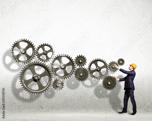 Photo: Businessman and mechanism elements Businessman and mechanism elements