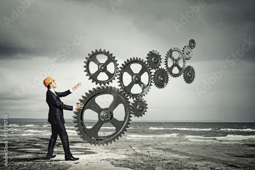 Photo: Businessman and mechanism elements Businessman and mechanism elements