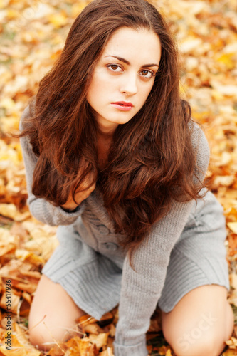 Photo: Autumn beautiful woman on leafs background Autumn beautiful woman on leafs background