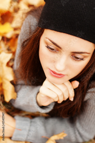 Photo: Autumn beautiful woman on leafs background Autumn beautiful woman on leafs background