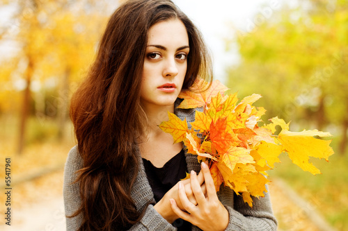 Photo: Autumn beautiful woman on leafs background Autumn beautiful woman on leafs background