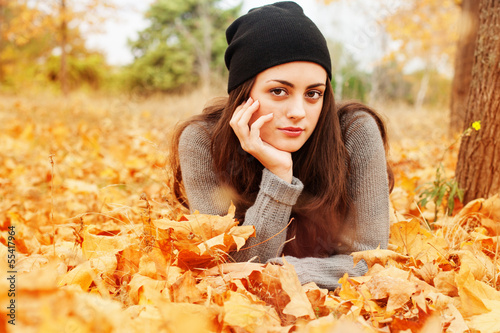 Photo: Autumn beautiful woman on leafs background Autumn beautiful woman on leafs background