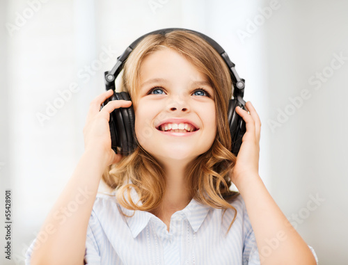 Photo: little girl with headphones at home little girl with headphones at home