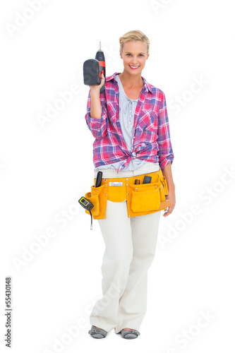 Photo: Woman standing holding a drill Woman standing holding a drill