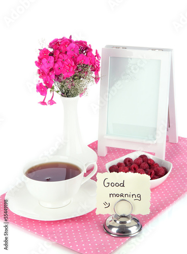 Photo: Beautiful bouquet of phlox with cup of tea isolated on white Beautiful bouquet of phlox with cup of tea isolated on white