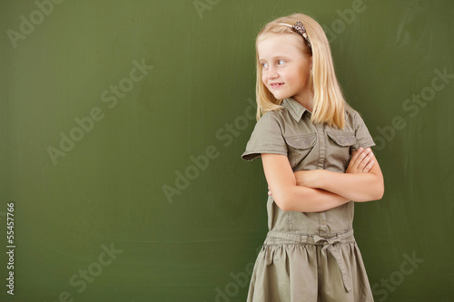 Photo: Scoolgirl standing near blackboard Scoolgirl standing near blackboard