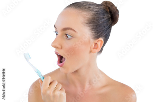 Photo: Young model looking at her toothbrush Young model looking at her toothbrush
