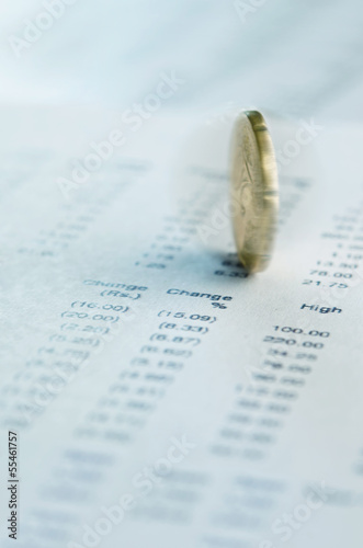 Photo: Coin spinning on financial reports Coin spinning on financial reports