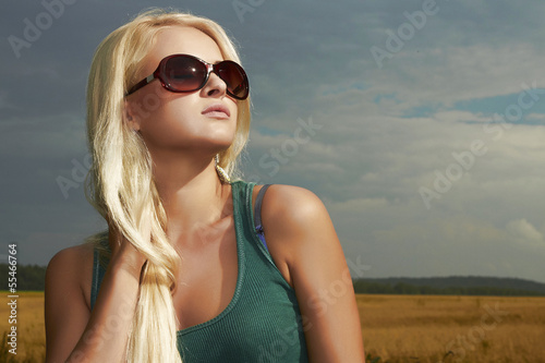 Photo: Beautiful blond girl.nature background.beauty woman.sunglasses Beautiful blond girl.nature background.beauty woman.sunglasses