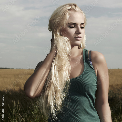 Photo: Beautiful blond girl on the field.beauty woman.nature Beautiful blond girl on the field.beauty woman.nature