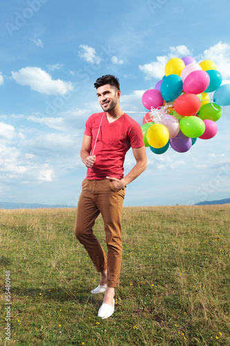 Photo: casual man with baloons over his shoulder casual man with baloons over his shoulder