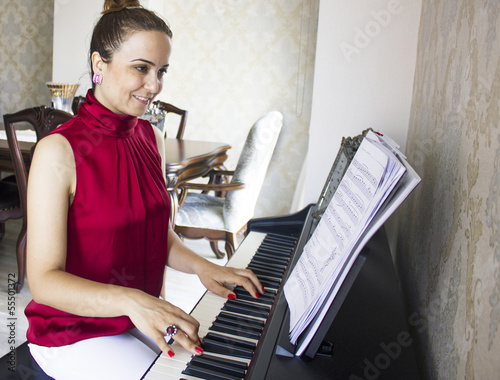 Photo: red shirted woman playing the piano red shirted woman playing the piano
