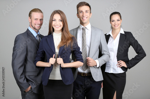 Photo: Business team standing in row on grey background Business team standing in row on grey background