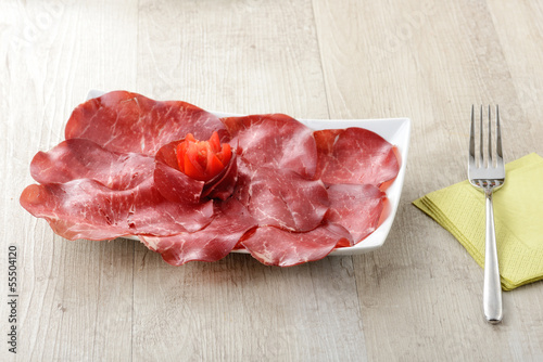 Photo: Piatto di bresaola con tovagliolo e forchetta Piatto di bresaola con tovagliolo e forchetta