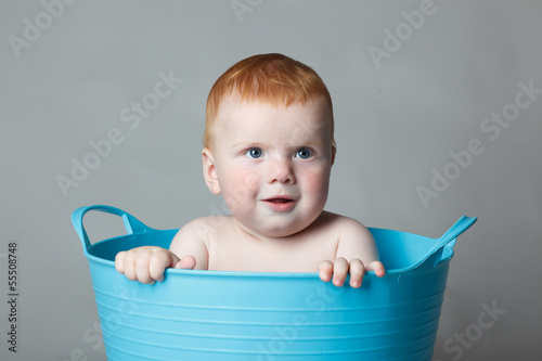 Photo: laughing baby in a blue bucket laughing baby in a blue bucket