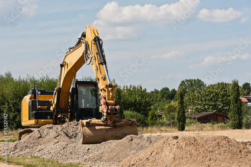 Photo: Ein gelber Bagger mit breiter Schaufel bei Erdarbeiten Ein gelber Bagger mit breiter Schaufel bei Erdarbeiten