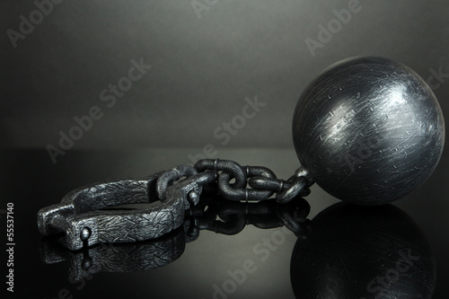 Photo: Ball and chain on grey background Ball and chain on grey background