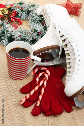 Photo: Figure skates with cup of coffee on table close-up Figure skates with cup of coffee on table close-up