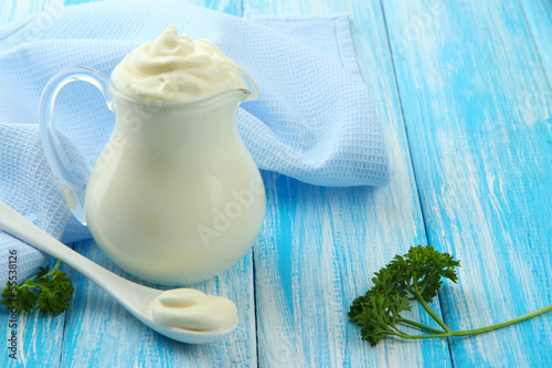Photo: Sour cream in pitcher on table close-up Sour cream in pitcher on table close-up