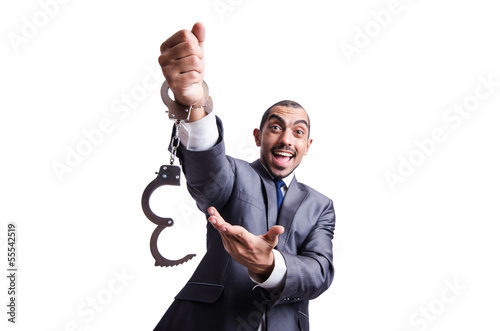 Photo: Funny businessman with handcuffs on white Funny businessman with handcuffs on white