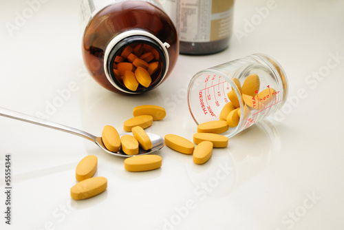 Photo: nutritional supplement (drug pills) in spoon and containers nutritional supplement (drug pills) in spoon and containers