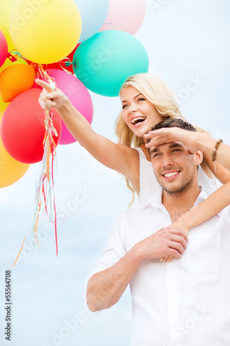 Photo: couple with colorful balloons at seaside couple with colorful balloons at seaside