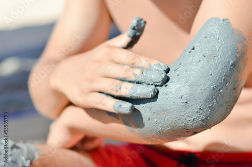 Photo: Man applying mineral blue mud on elbow Man applying mineral blue mud on elbow
