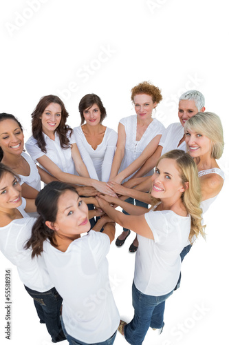 Photo: Happy female models joining hands in a circle and looking at cam Happy female models joining hands in a circle and looking at cam