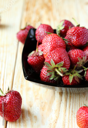 Photo: ripe strawberries in a bowl on the table ripe strawberries in a bowl on the table
