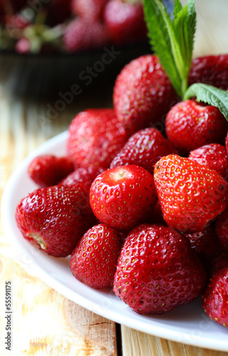 Photo: pile ripe strawberries on a white plate pile ripe strawberries on a white plate