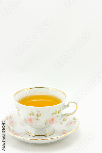 Photo: porcelain tea cup full of tea on a white background porcelain tea cup full of tea on a white background