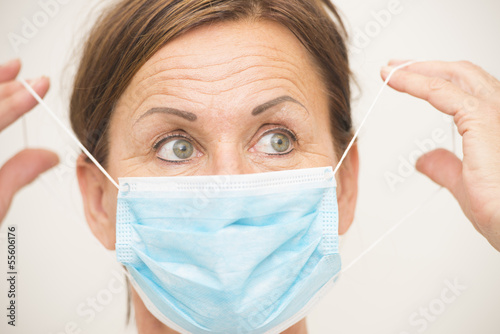 Photo: Female nurse or doctor with mask over face Female nurse or doctor with mask over face
