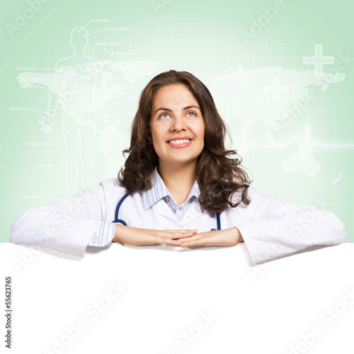 Photo: young woman doctor with a blank banner young woman doctor with a blank banner