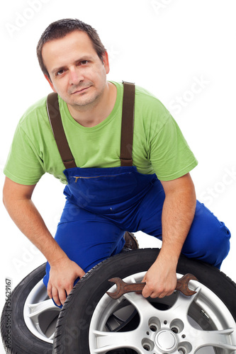Photo: Car mechanic with tires Car mechanic with tires