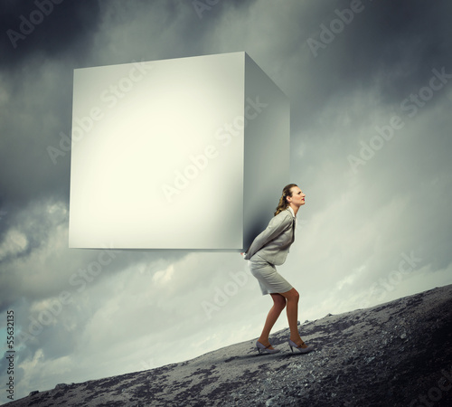 Photo: Businesswoman carrying cube Businesswoman carrying cube