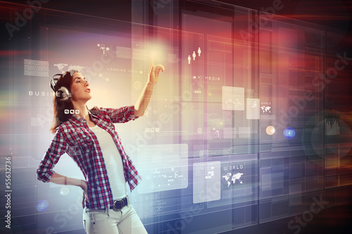 Photo: Woman touching virtual screen Woman touching virtual screen