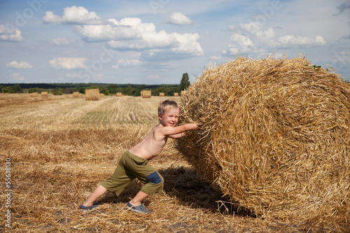 Photo: Boy with bale of straw Boy with bale of straw