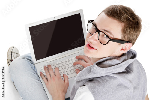 Photo: Young happy man with laptop sitting on the floor Young happy man with laptop sitting on the floor