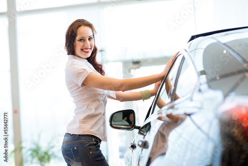 Photo: young woman standing near a car young woman standing near a car