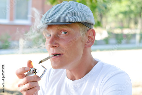 Photo: Happy smoker lighting up a cigarette Happy smoker lighting up a cigarette