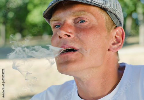 Photo: Man blowing smoke out of his mouth Man blowing smoke out of his mouth