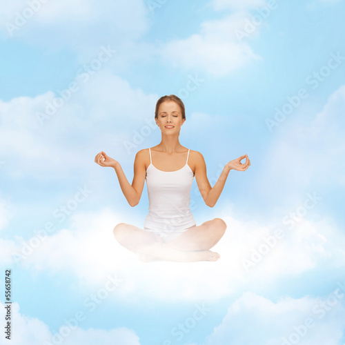 Photo: girl sitting in lotus position and meditating girl sitting in lotus position and meditating