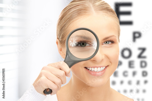 Photo: woman with magnifier and eye chart woman with magnifier and eye chart
