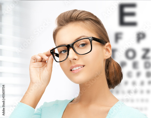 Photo: woman in eyeglasses with eye chart woman in eyeglasses with eye chart