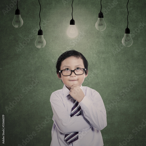 Photo: Business boy thinking under lamps Business boy thinking under lamps