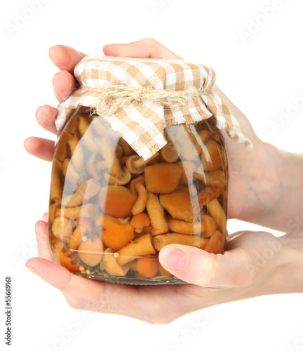 Photo: Female hands with delicious marinated mushrooms in glass jars, Female hands with delicious marinated mushrooms in glass jars,